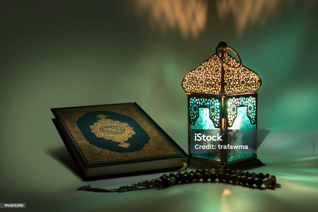Traditional lantern and Muslims Holy book Quran This kind of photos used as greeting cards for ramadan month and eid, also as a background for some holy book words Eid-Ul-Fitr Stock Photo