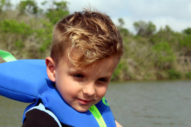 istock Boy Riding in Boat Wearing Life Jacket 944816032