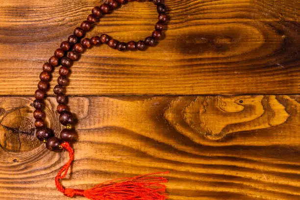 Photo of Brown rosary on the wooden table. Top view