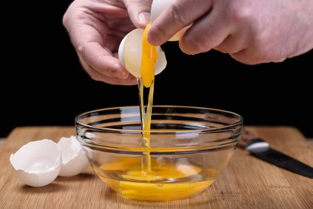 istock Extraction of egg yolk into a bowl 944822396