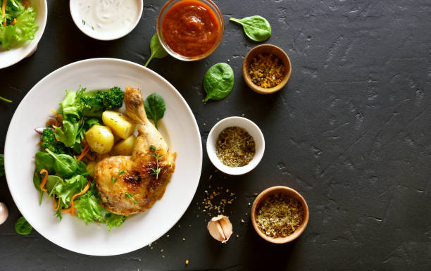 istock Chicken leg with potato and green salad 944822590