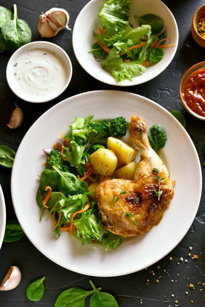 istock Chicken leg with potato and green salad 944822592