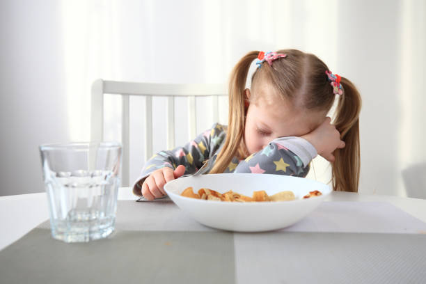 bambina che si addormenta a colazione - little girls small eating breakfast foto e immagini stock