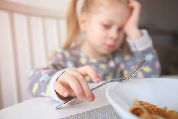 istock Sad little girl with spoon 944826228