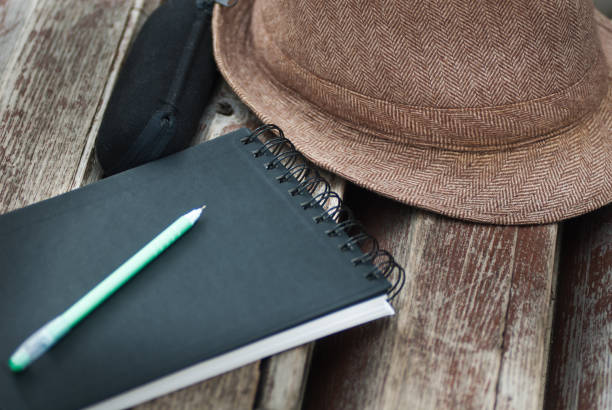 istock natepad, pan, glasses case and hat on bench in park close up 944831058