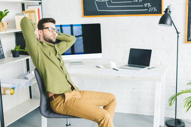 istock Tired businessman stretching by working table at home office 944841438