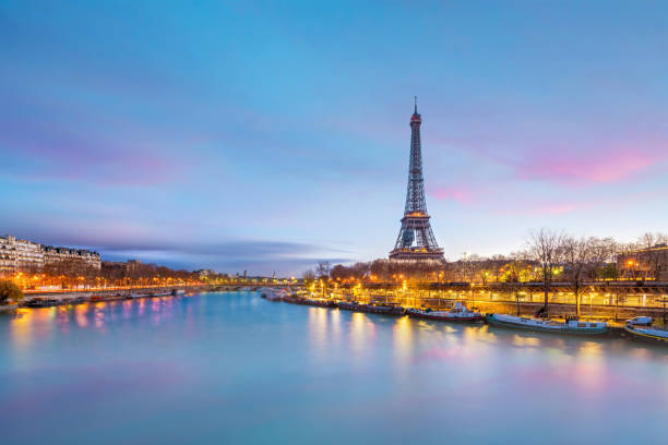 der eiffelturm und das seineufer in der dämmerung in paris - eifelturm stock-fotos und bilder