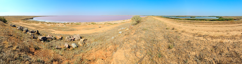 Pink extremely salty Syvash Lake, colored by microalgae (Putrid Rotten Sea). And blue fresh lake by the dam. Ukraine, Kherson Region, near Crimea and Arabat Spit. High-resolution four shots panorama.