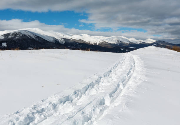 istock Sledge trace and footprints on winter mountain hill top 944852478