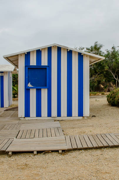 Blue striped beach hut in the sand