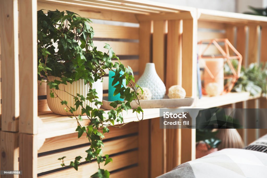 Wooden drawer shelves Wooden drawer shelves with decor. Creative head of the bed, shelves for decor in the loft style or Scandinavia. Trend elements of the interior. Pot with ivy Shelf Stock Photo