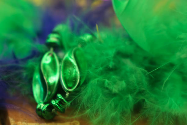 colorful green and purple blurred mardi gras background with feathers and beads - mardi gras new orleans feather mask imagens e fotografias de stock