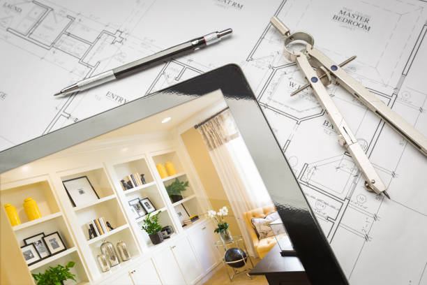 istock Computer Tablet with Finished Built-in Shelves and Cabinets Over House Plans, Pencil and Compass. 944868076