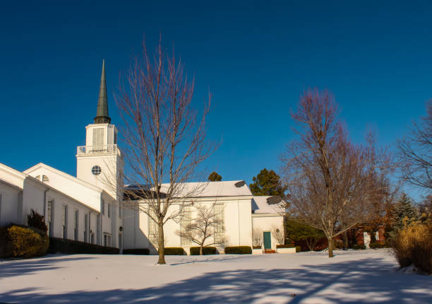 istock White church with steeple in the snow with deep blue sky 944868716