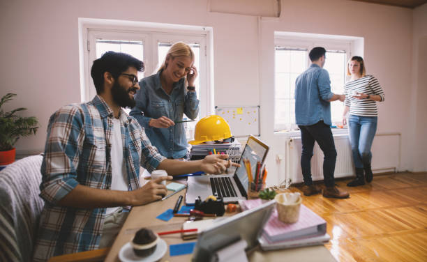istock Group of young productive engineer people talking to each other and planing next innovative ideas in the large office. 944869310