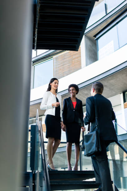 istock Young work colleagues standing face to face on the steps 944871684