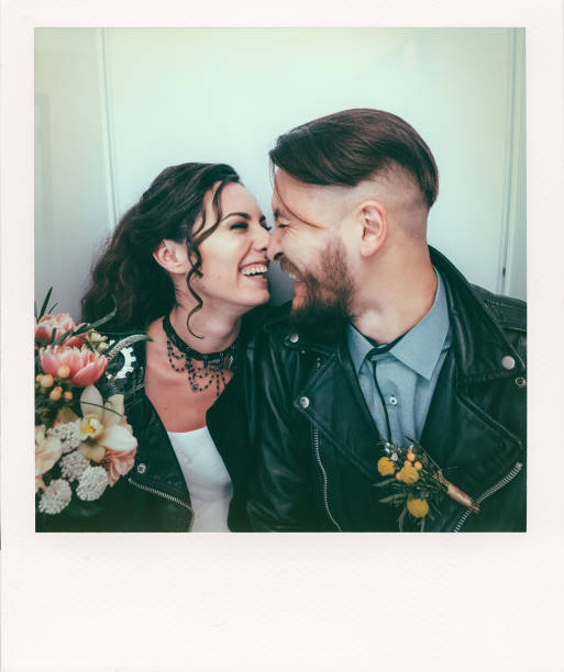 Wedding in the style of rock. Rocker or biker wedding. Guys with stylish leather jackets. It's a rocknroll baby. The sweet couple are photographed in a photobooth. stock photo