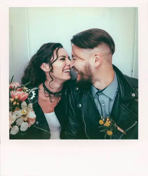 Photo of Wedding in the style of rock. Rocker or biker wedding. Guys with stylish leather jackets. It's a rocknroll baby. The sweet couple are photographed in a photobooth.