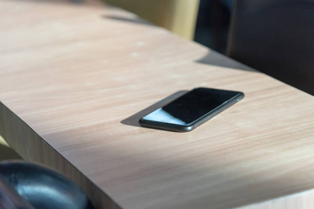 slimme telefoon plaats op houten tafel in een coffeeshop, concept: vergeten / verloren, selectieve aandacht - lost phone stockfoto's en -beelden