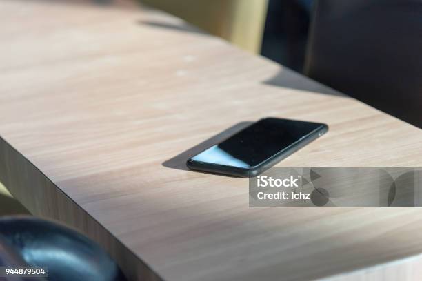 Smart Phone Place On Wooden Table In Coffee Shop Concept Forget Lost Selective Focus Stock Photo - Download Image Now