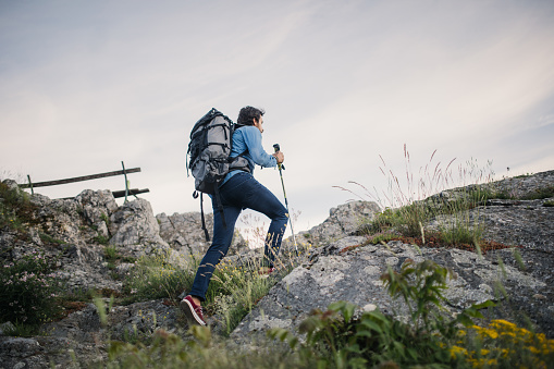 One man, walking high on mountain alone, rear view.