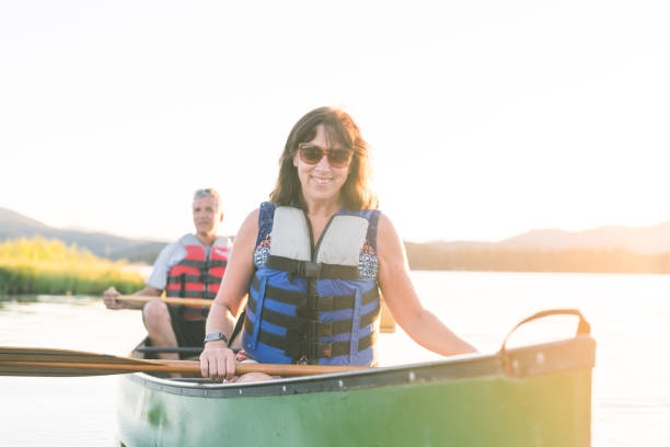 istock Middle-aged couple canoe together on a lake 944882656
