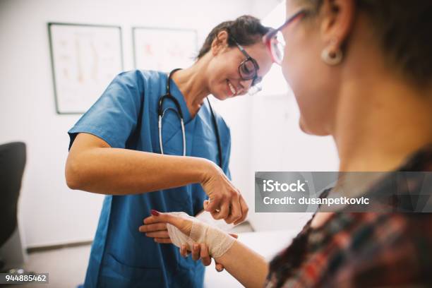 Professional Nurse At The Hospital Bandaging The Hand With A Medical Bandage For A Woman Patient Stock Photo - Download Image Now