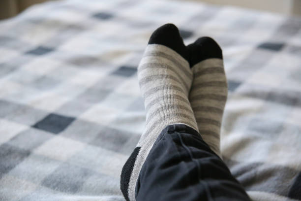 istock Striped stocking at a cozy bed. Chilling time. 944889794