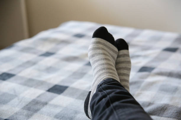 istock Striped stocking at a cozy bed. Chilling time. 944889824