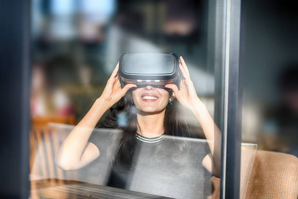 istock Young woman looking with VR behind the glass 944890794
