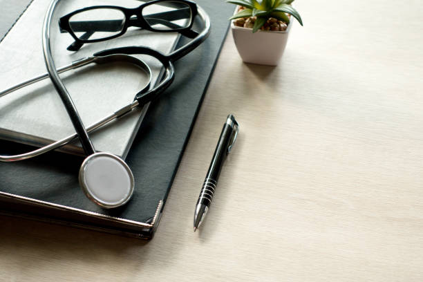 istock Stethoscope notebook and pen on wooden table. 944903910