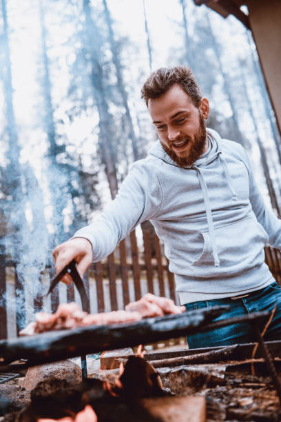 gut aussehend männlichen vorbereitung grill auf familien-picknick - barbecue chicken stock-fotos und bilder