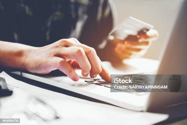 Mans Hands Typing Laptop Keyboard And Holding Credit Card Online Shopping Concept Stock Photo - Download Image Now