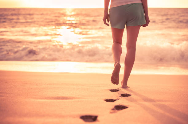 istock Woman walking on the beach 944914980
