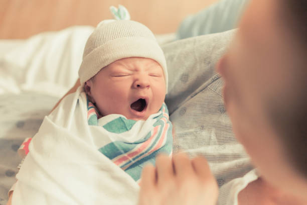 Sleepy baby yawning Mother holding cute newborn baby boy in here arms. labor childbirth photos stock pictures, royalty-free photos & images