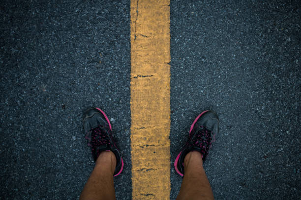istock Men runner feet on road in workout wellness concept. 944917398