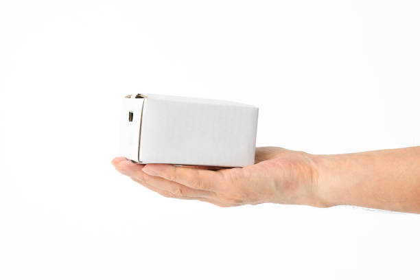 Holding a small blank cardboard box, isolated on white with clipping path.