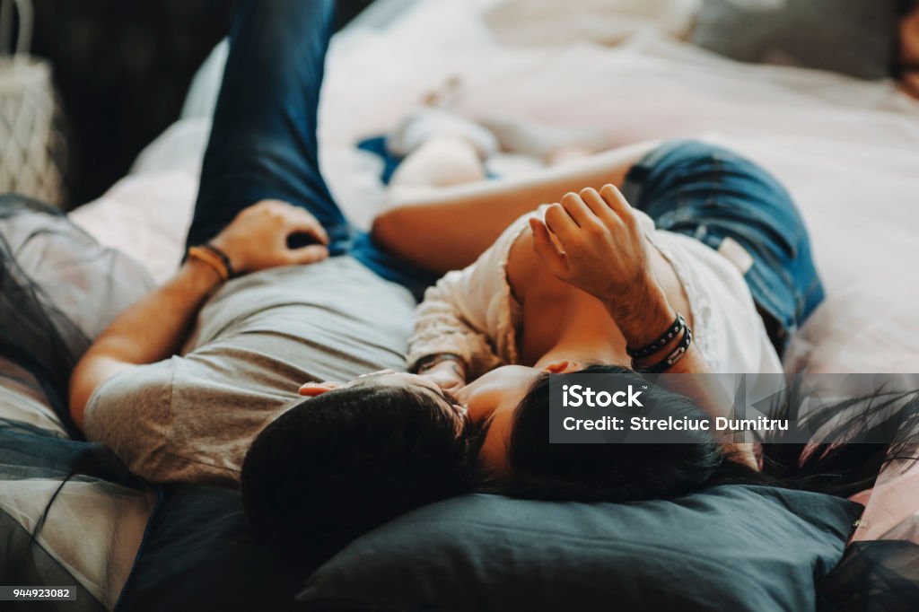 Attraktive romantisch zu zweit auf Bett, umarmen und küssen in einem gemütlichen Zimmer. - Lizenzfrei Paar - Partnerschaft Stock-Foto