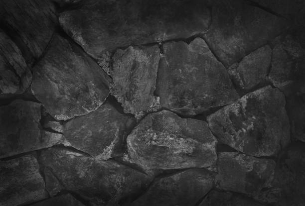 istock Stone wall background, black rock texture in natural pattern with high resolution for design art work. 944924380