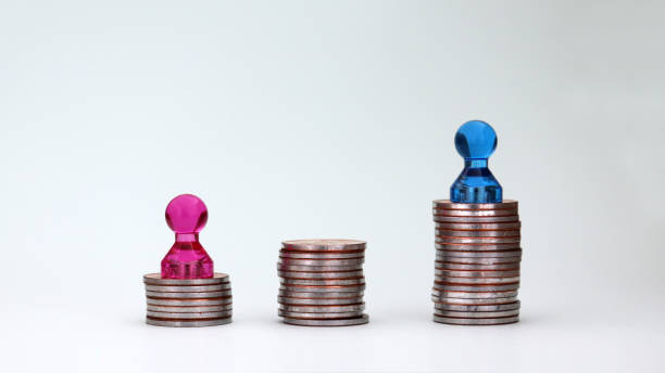A pile of coins and little magnets. The concept of gender pay gap. stock photo