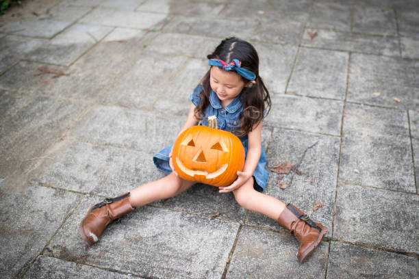 istock Little girl and Jack O'Lantern 944945278