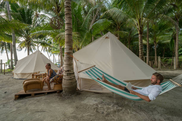 istock Young couple relaxing in glamping campground in tropical scenery 944945558