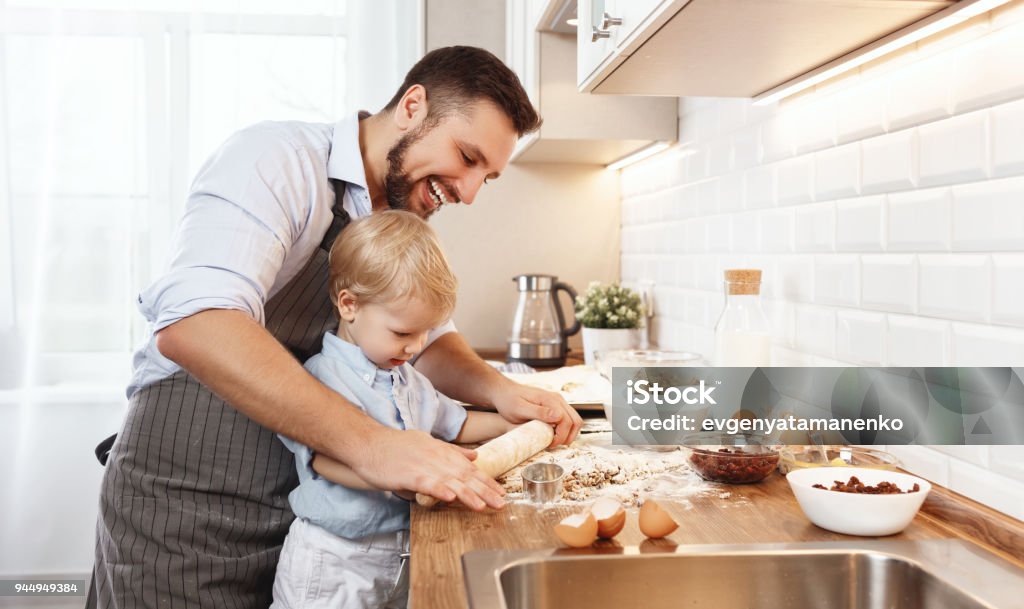 famiglia felice in cucina. biscotti da forno padre e bambino - Foto stock royalty-free di Cucinare