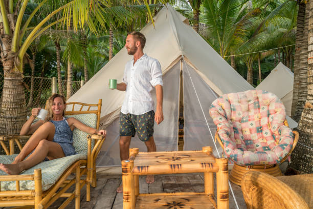 istock Young couple relaxing in glamping campground in tropical scenery 944949634