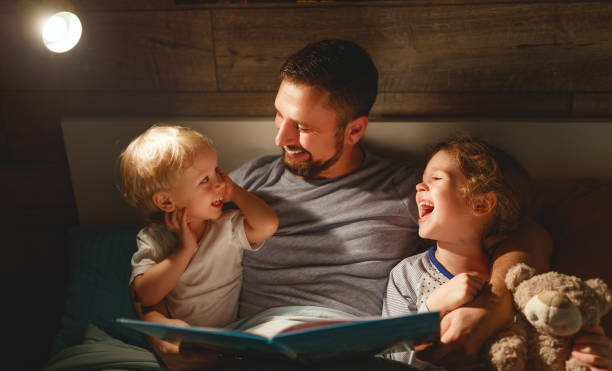 istock evening family reading. father reads children . book before going to bed 944949780