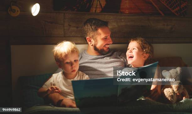 Evening Family Reading Father Reads Children Book Before Going To Bed Stock Photo - Download Image Now