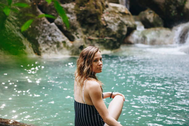 istock White woman enjoying the waterfall 944960560