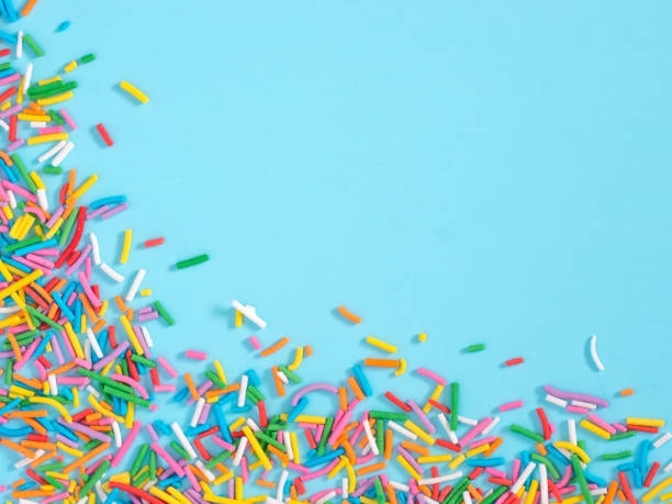 istock Border frame of colorful sprinkles on blue background 944962184