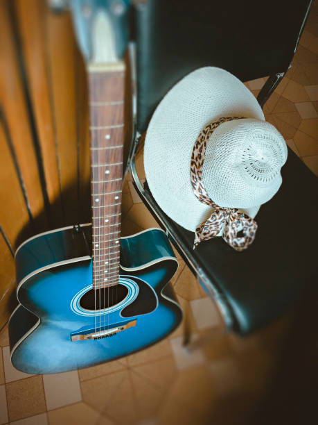 Acoustic guitar with lady's hat.