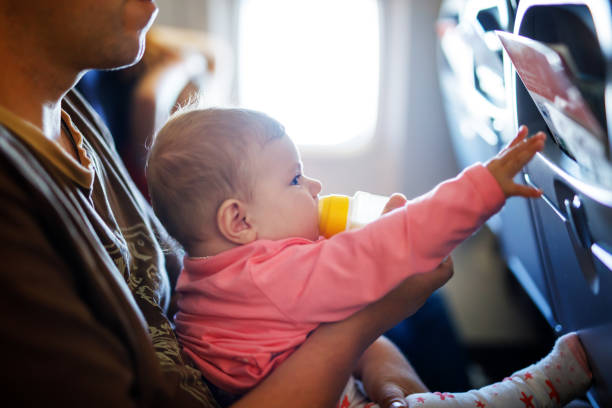 istock Father holding his baby daughter during flight on airplane going on vacations 944969516
